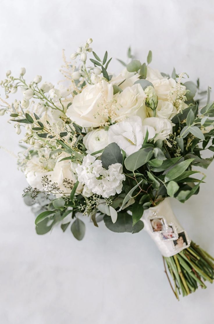 a bridal bouquet with white flowers and greenery on a white background for a wedding