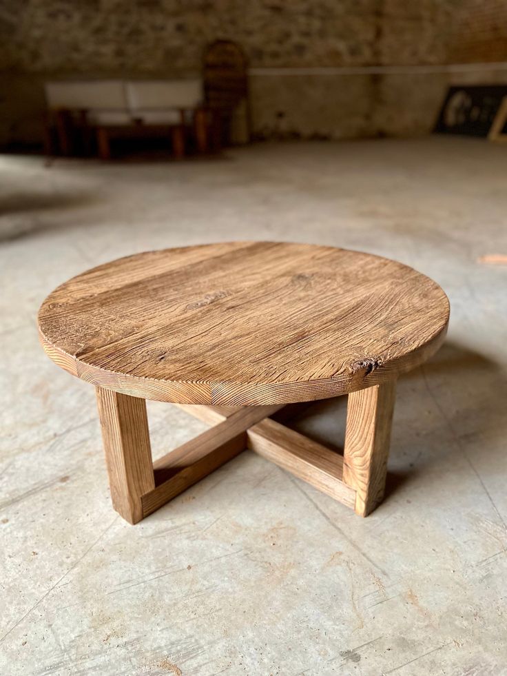 a round wooden table sitting on top of a floor