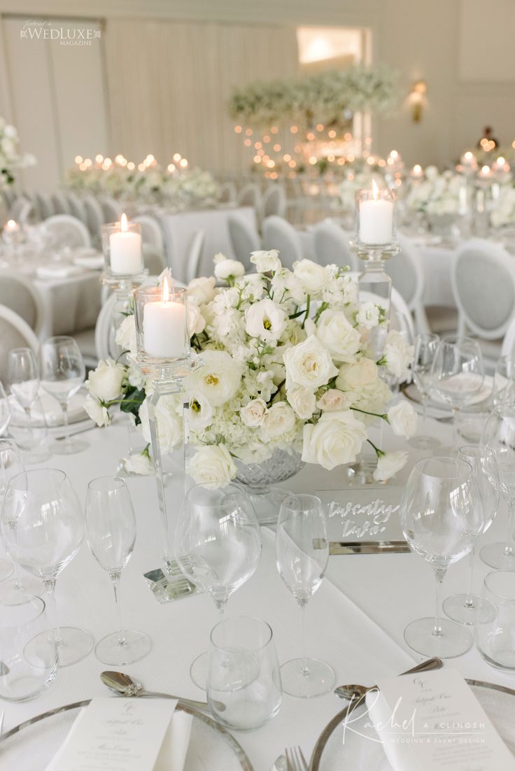 a table with white flowers and silverware is set for a formal dinner or reception