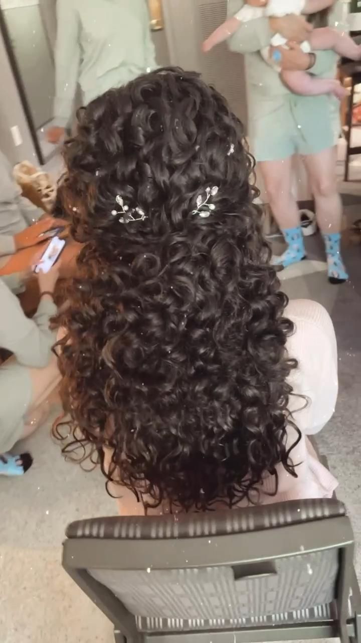 the back of a woman's head with curly hair in front of other people