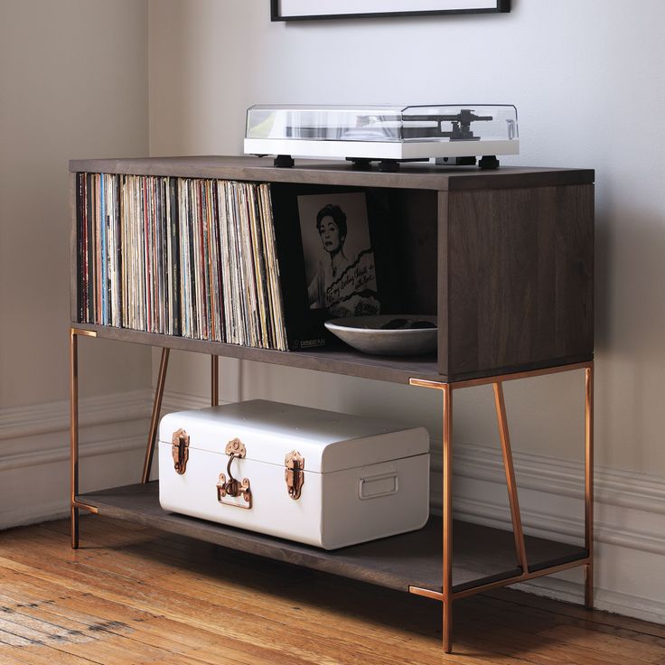 a record player sitting on top of a wooden shelf next to a white suitcase and record player