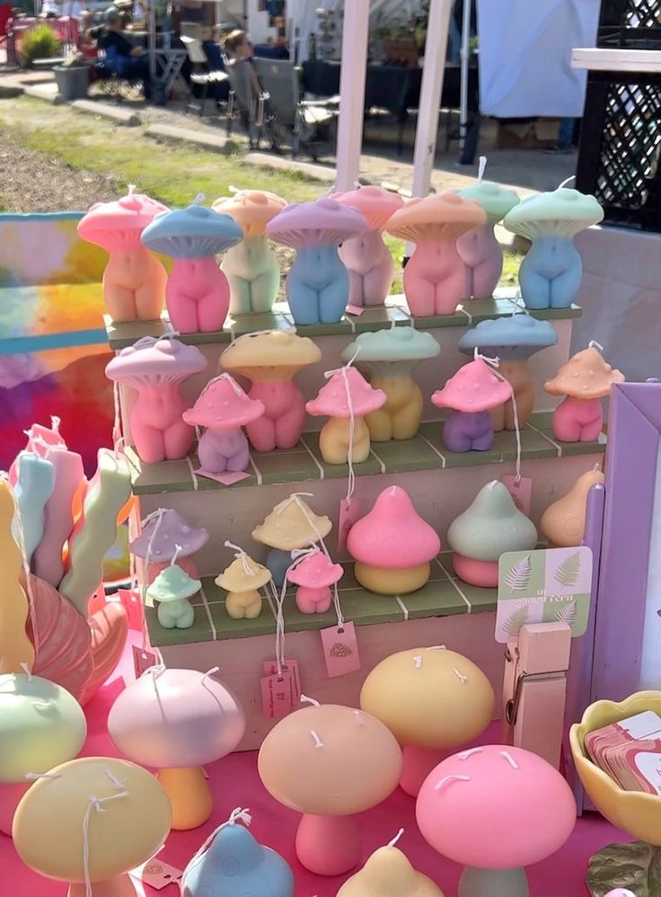 there are many different items on the table for sale at this outdoor market, including balloons and candles