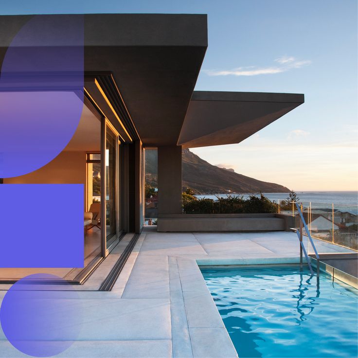 an outdoor swimming pool next to a house with a view of the ocean and mountains