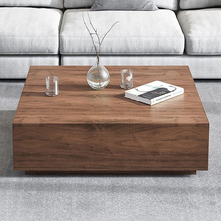 a coffee table sitting on top of a gray carpeted floor next to a couch