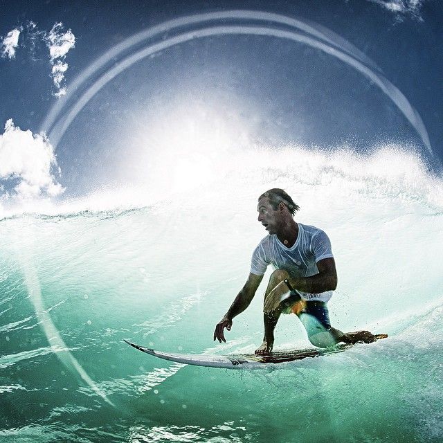 a man riding a wave on top of a surfboard in the ocean under a blue sky