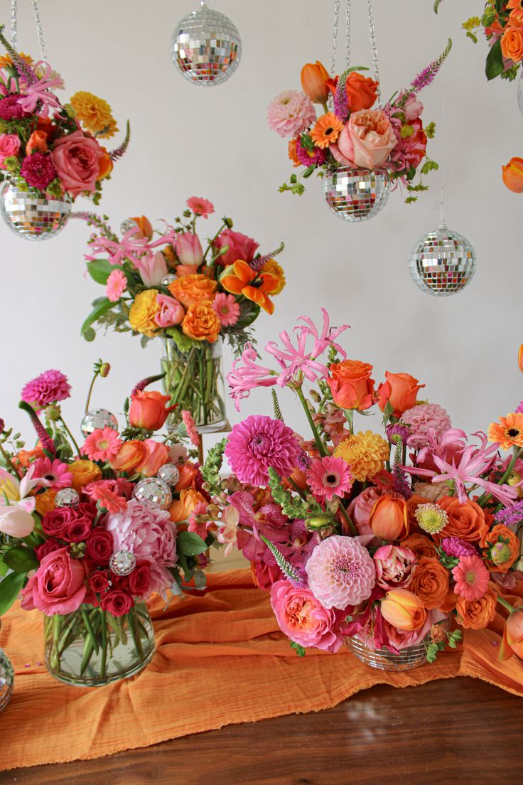 a table full of pink and orange flower arrangements with disco mirror balls Special Occasion, Floral Party, Event Flower Arrangements, Event Flowers, Flower Ball, Pink Orange Wedding Flowers, Floral Theme, Colorful Bouquet, Floral Birthday Party