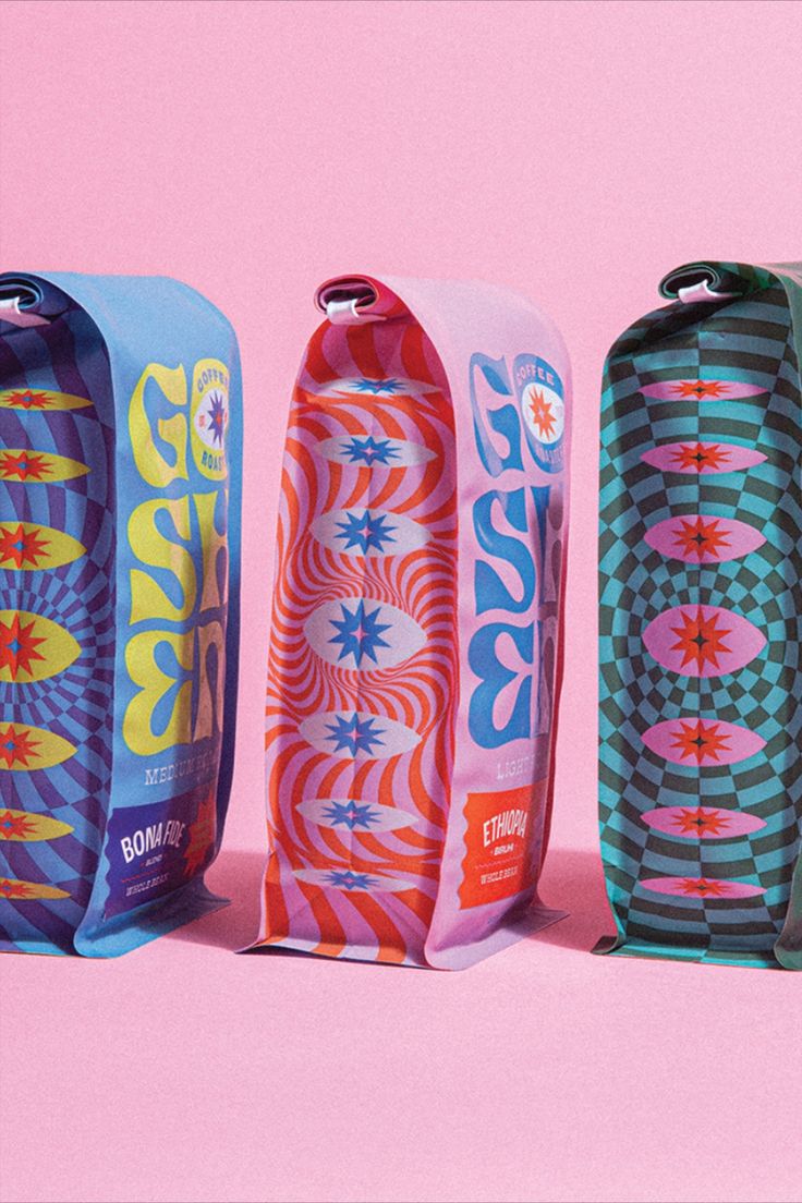 three skateboards are lined up against a pink background and one is in the shape of a flower
