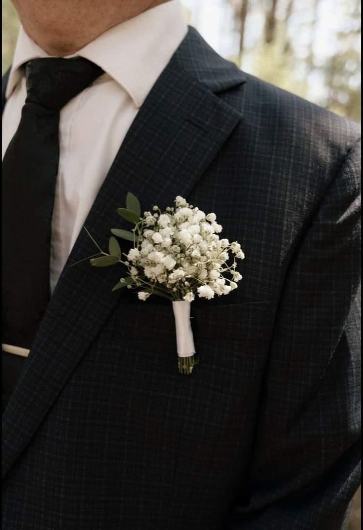 a man in a suit and tie with a boutonniere on his lapel