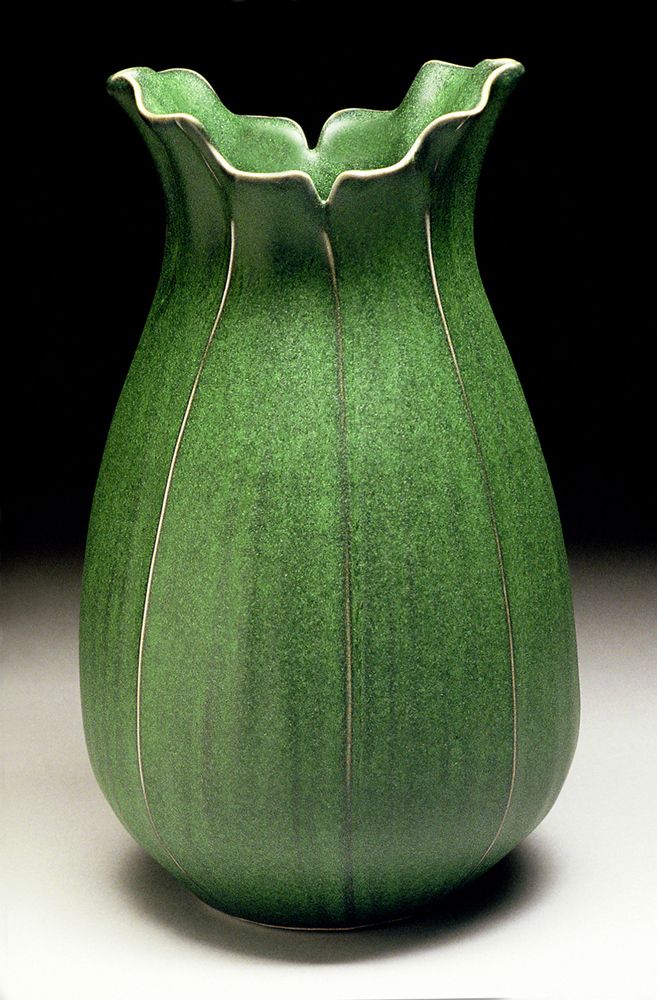 a green vase sitting on top of a table