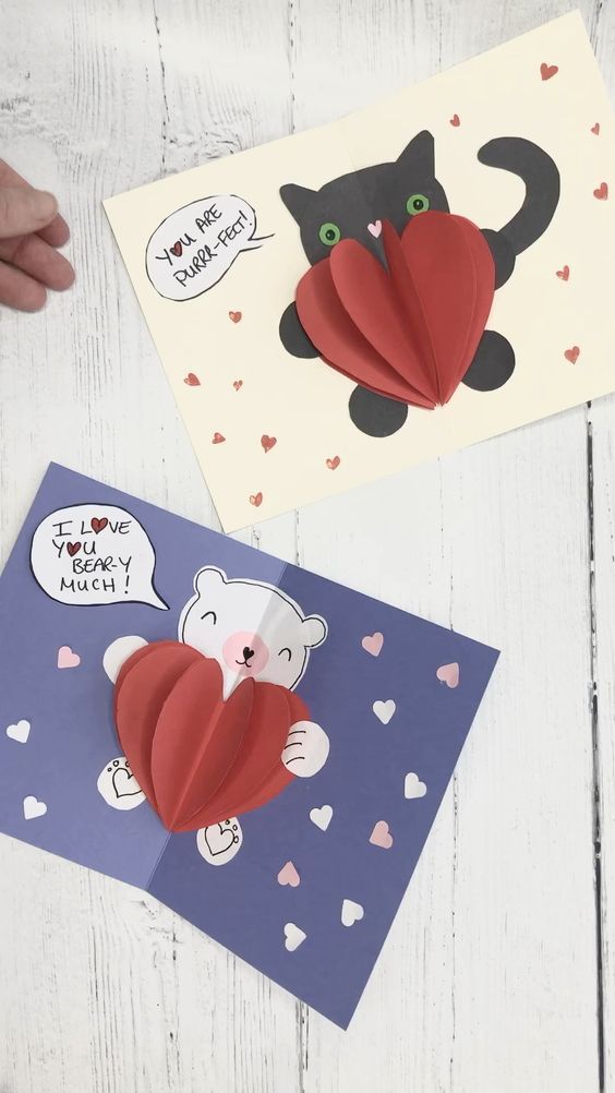 two handmade valentine cards with one holding a heart