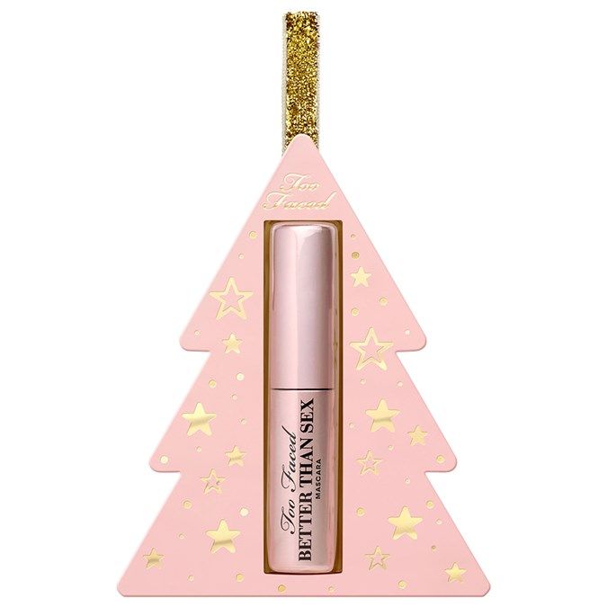 a pink christmas tree ornament with gold stars on it