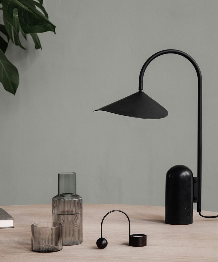 a black lamp sitting on top of a wooden table