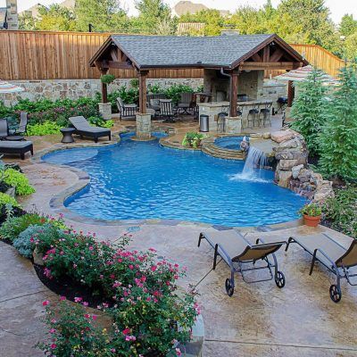 a backyard with a pool and patio furniture