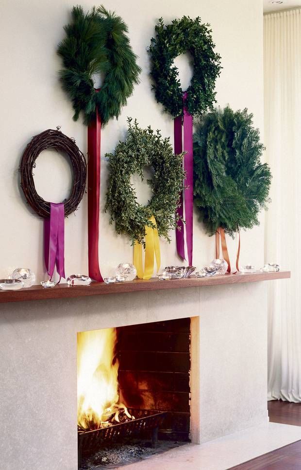 a fireplace with wreaths and candles on it