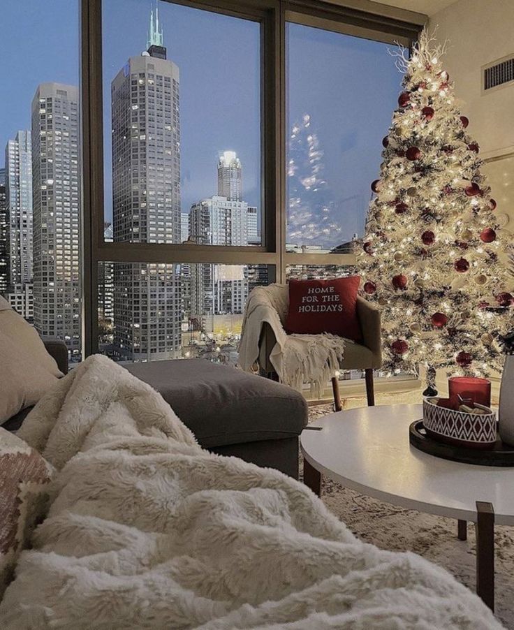 a living room filled with furniture and a christmas tree in front of a large window