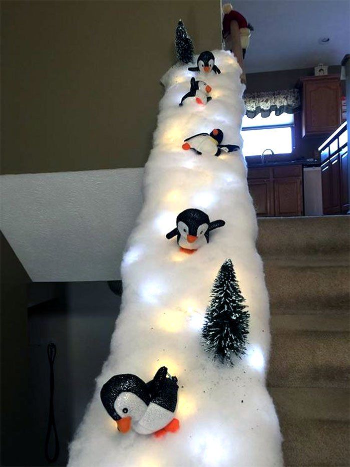a christmas tree made out of snow with penguins on it