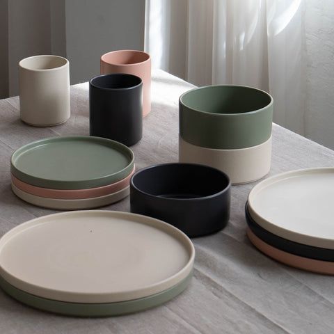 there are many plates on the table with different colors and shapes in this photo, one is empty
