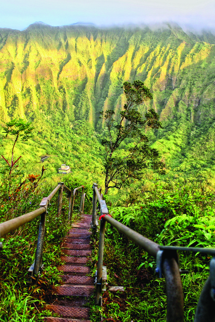 stairs leading up to the top of a mountain with lush green mountains in the background