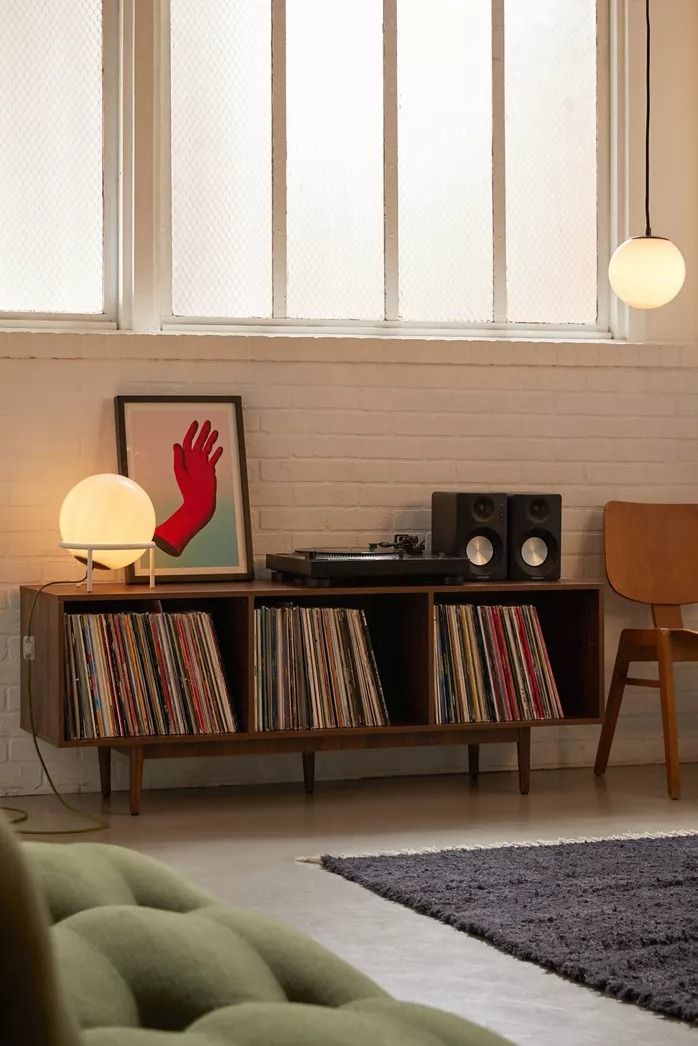a living room with an entertainment center and various records on the shelf next to it