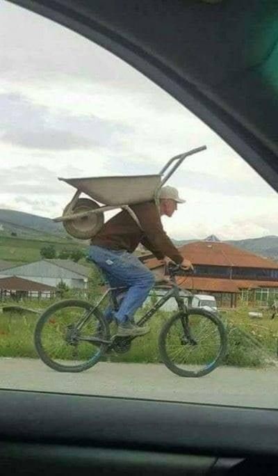 a man riding a bike with a hat on his head and the caption reads, the aoc approved green new deal dump truck