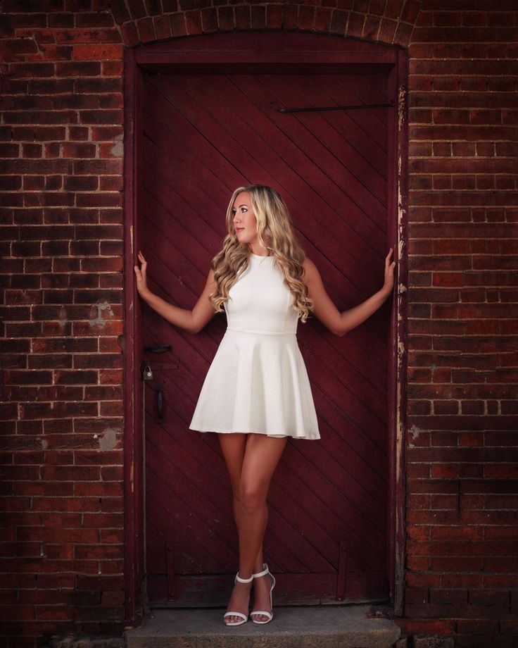 a beautiful young woman posing in front of a door