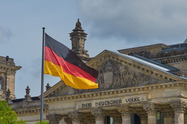 the german flag is flying in front of an old building