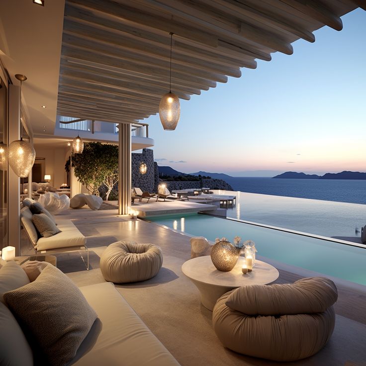 an outdoor living area with couches and tables next to the pool at night time