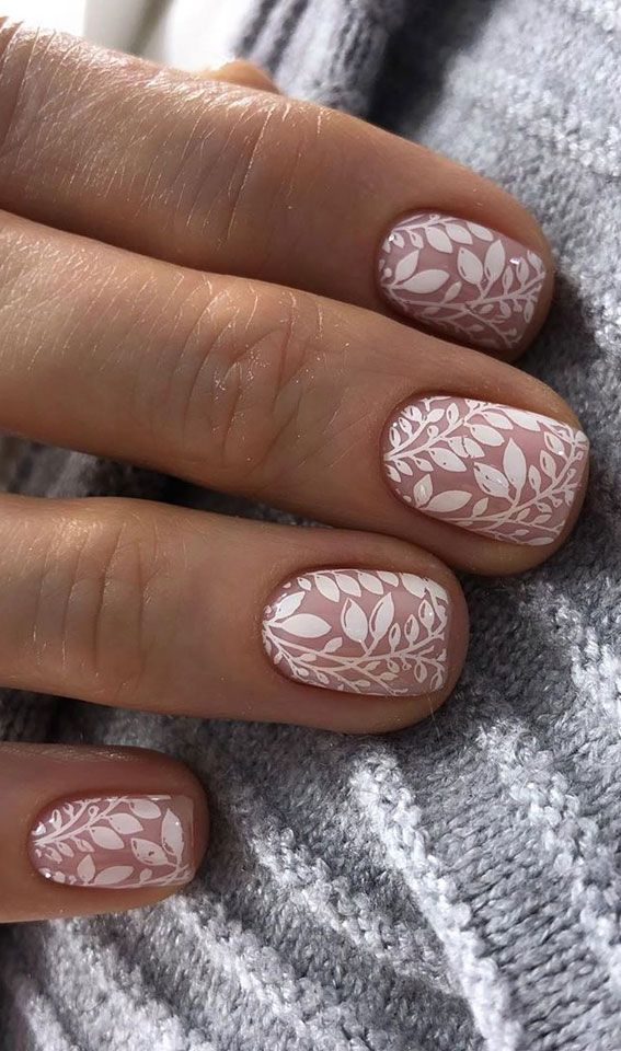 a woman's hand with white and pink manies on her nails, while she is