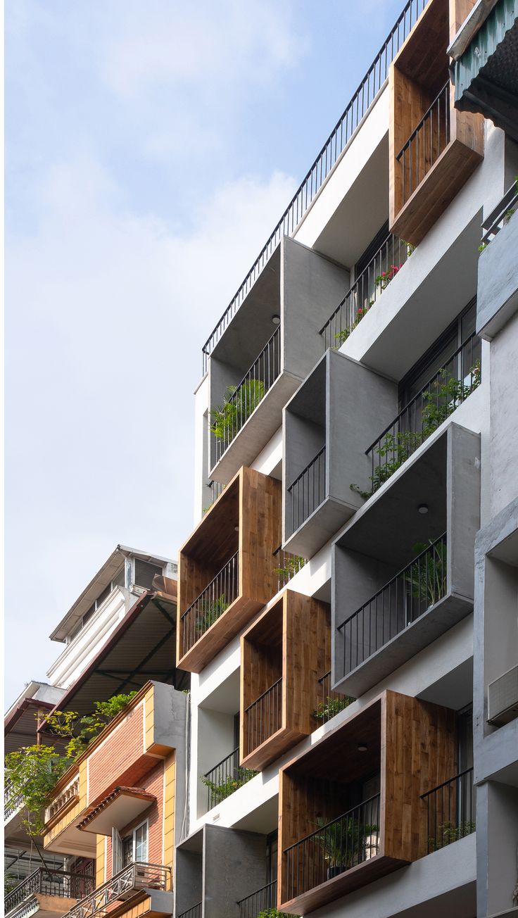 an apartment building with balconies and plants on the balconies