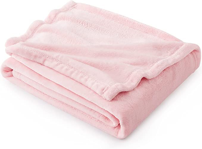 the pink blanket is folded on top of each other