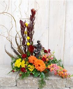 an arrangement of flowers is sitting on a stone ledge