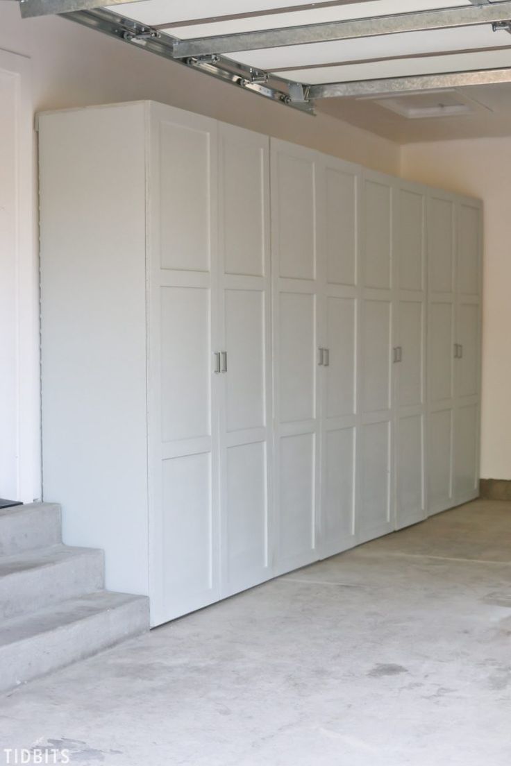 an empty garage with white cabinets and stairs