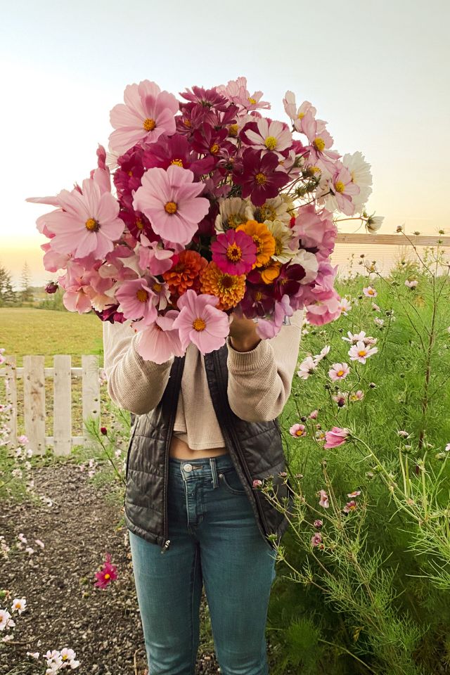a woman holding a bunch of flowers over her face
