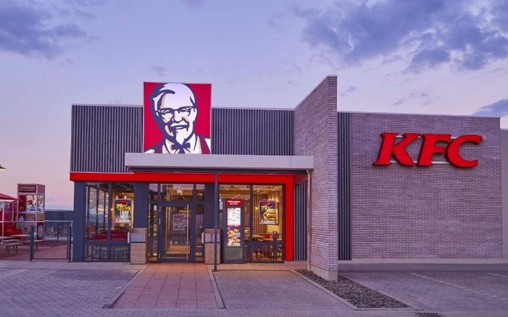 a kfc building with a large sign on it's front door and red awnings
