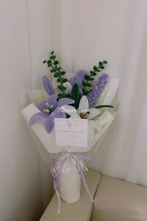a bouquet of flowers sitting on top of a white shelf next to a wall with a tag