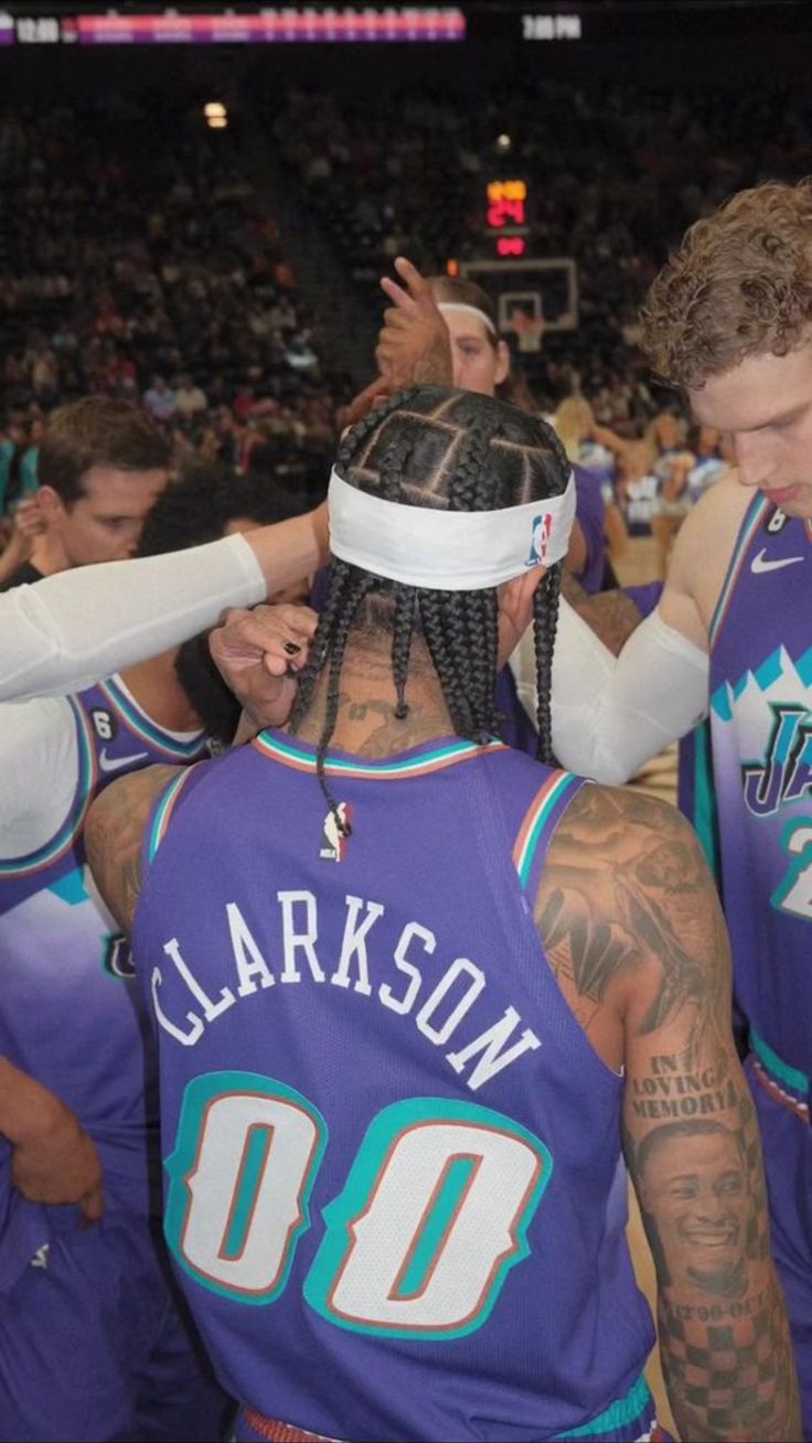 the basketball players are all huddled together in their uniforms and one is wearing a blindfold