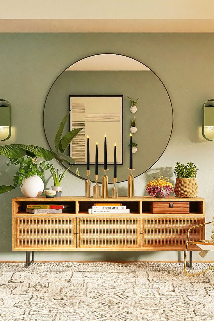 a living room with a round mirror above the console and plants on the sideboard