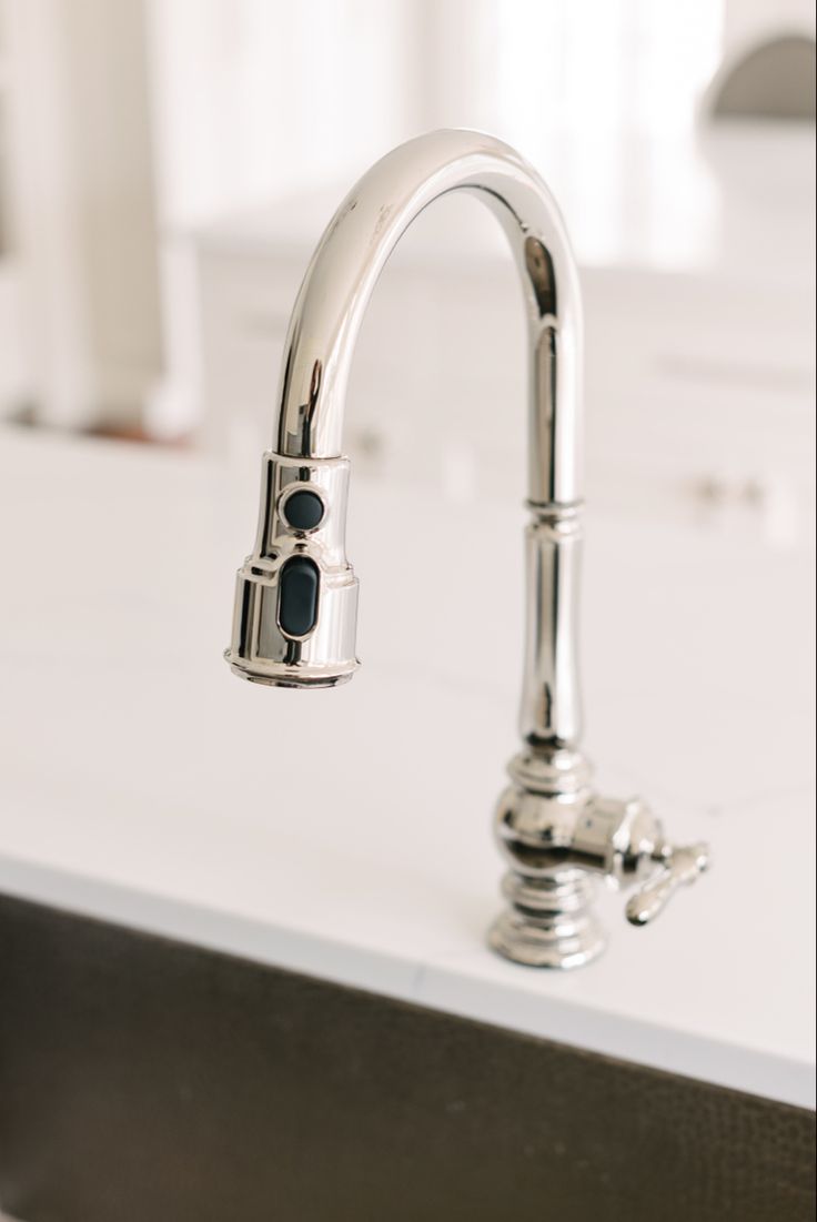 a chrome faucet on a white counter top