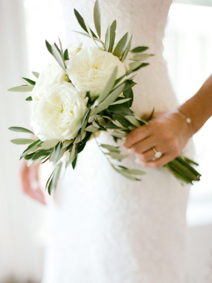 a bride holding a bouquet of white flowers
