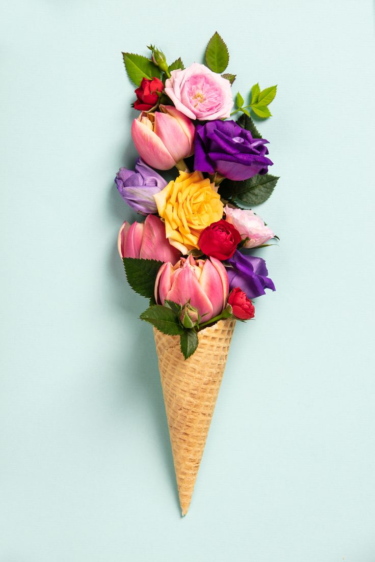 an ice cream cone filled with colorful flowers