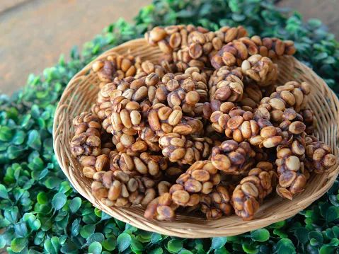 a basket filled with nuts sitting on top of green leaves