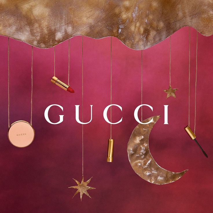 the gucci logo is hanging from strings with stars and lipstick on them, along with other items