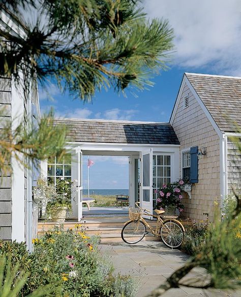 a bicycle is parked in front of a house with the ocean in the back ground