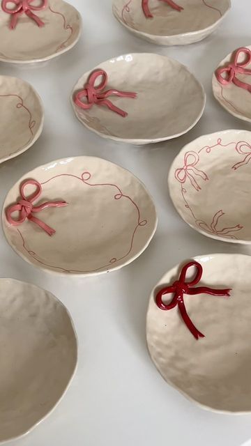 many plates with red bows on them sitting on a table
