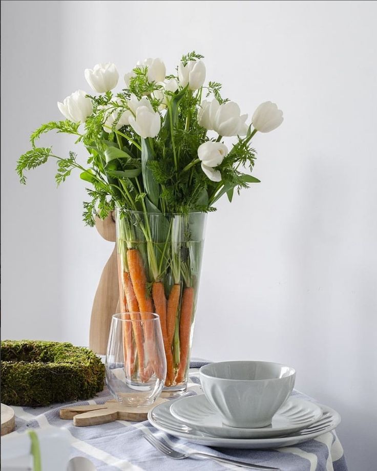 a vase filled with white flowers sitting on top of a table