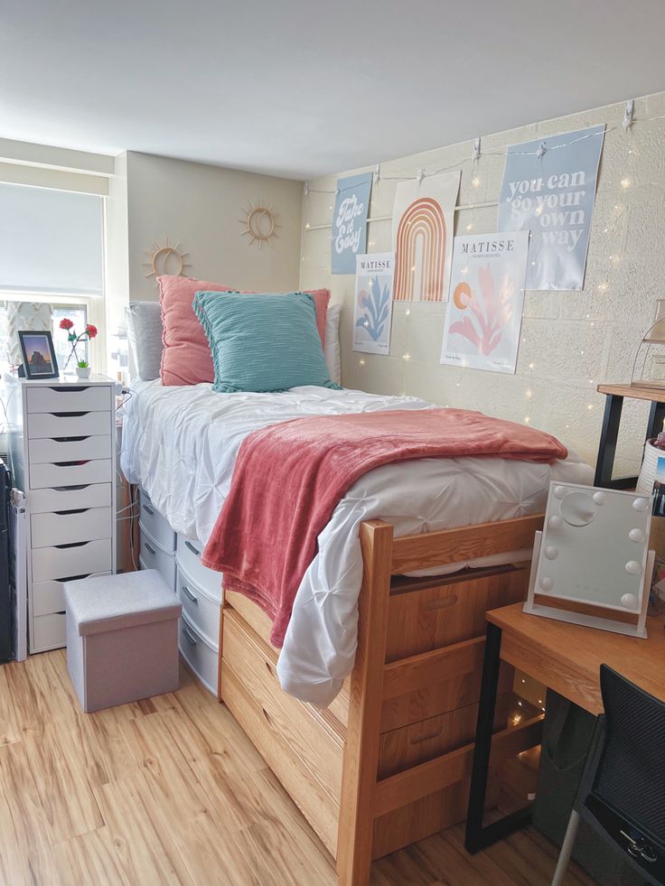 a bedroom with a bed, desk and drawers on the bottom shelf in front of it