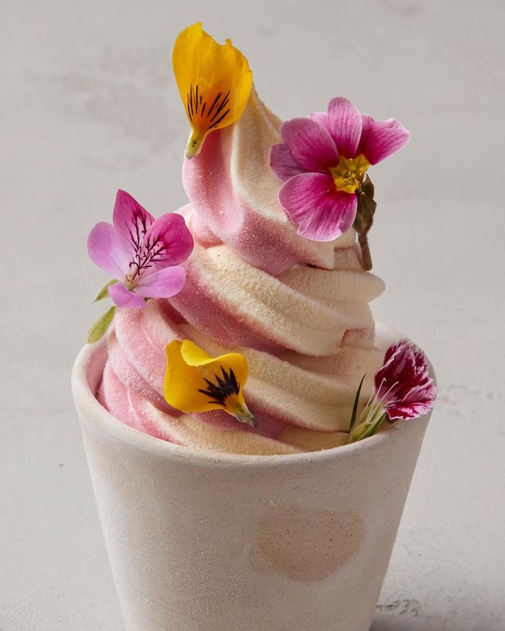 an ice cream sundae with pink and yellow flowers