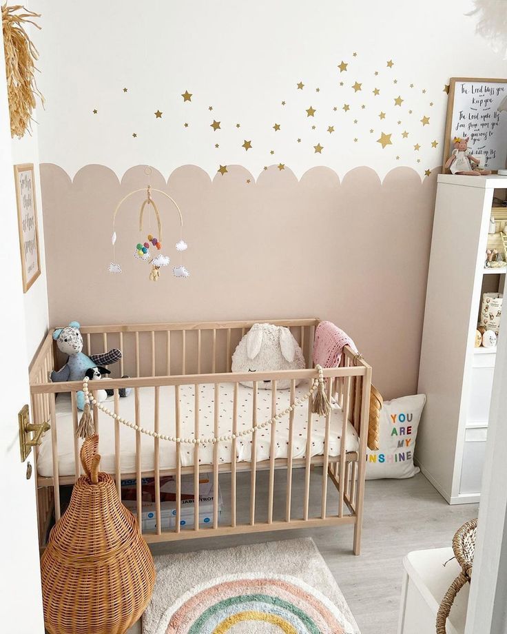 a baby's room decorated in pink and gold with stars on the wall above