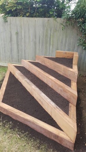 wooden steps made out of dirt in front of a fence