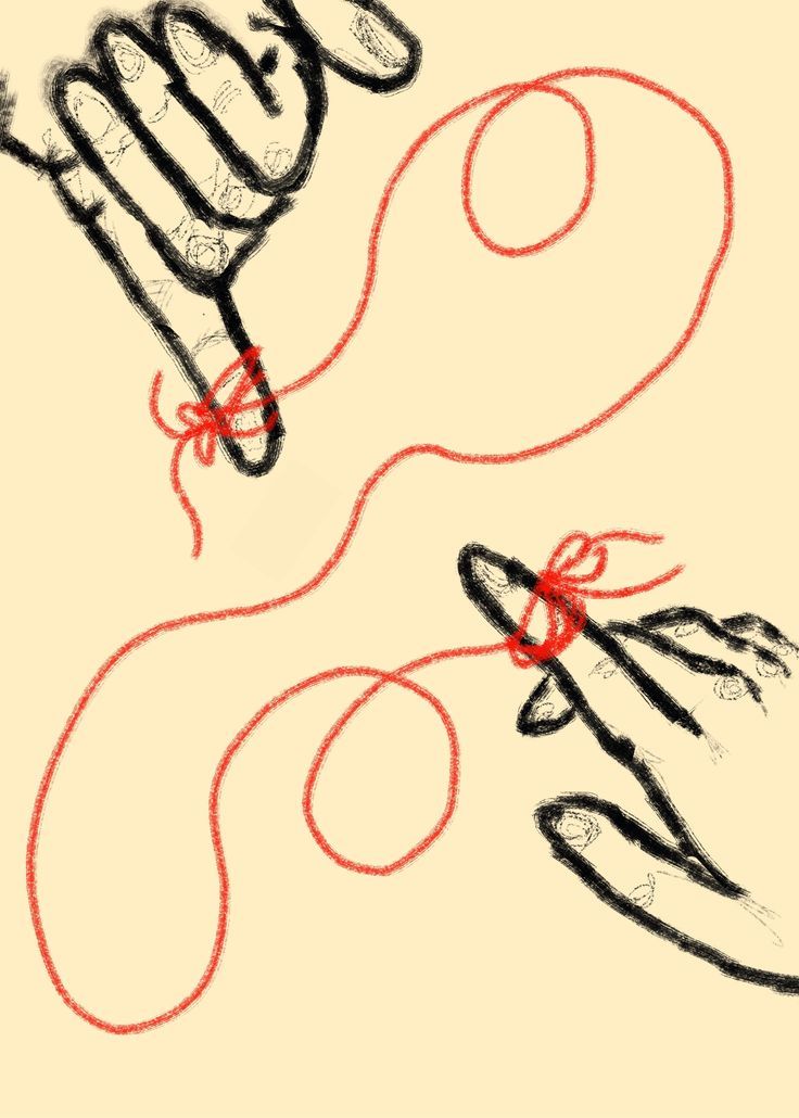two hands holding scissors with red string on them